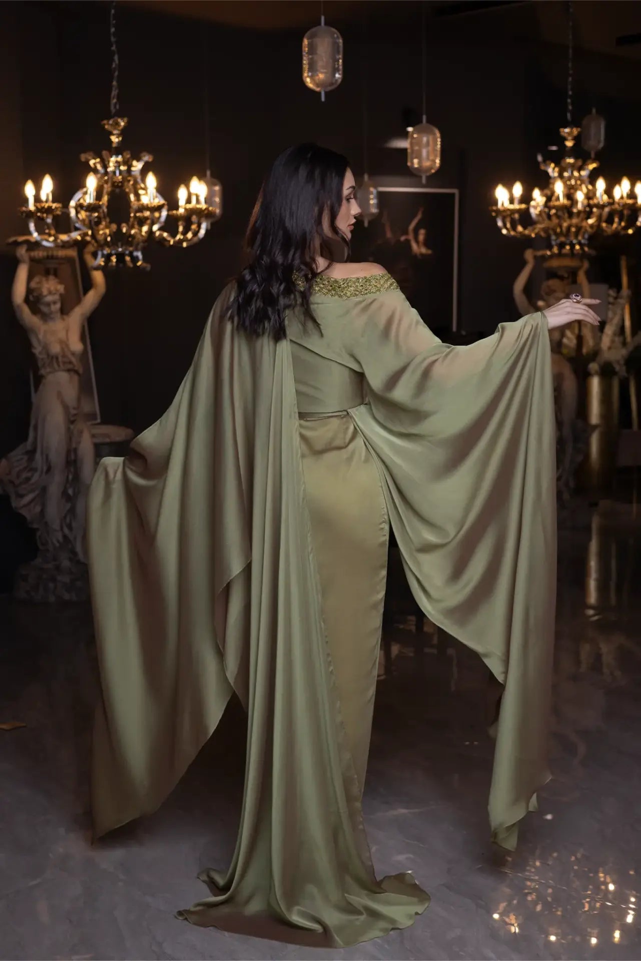 Back view of the Vérité Majestique 2025 Baroque Dress with dramatic chiffon cape sleeves and intricate one-shoulder detailing.