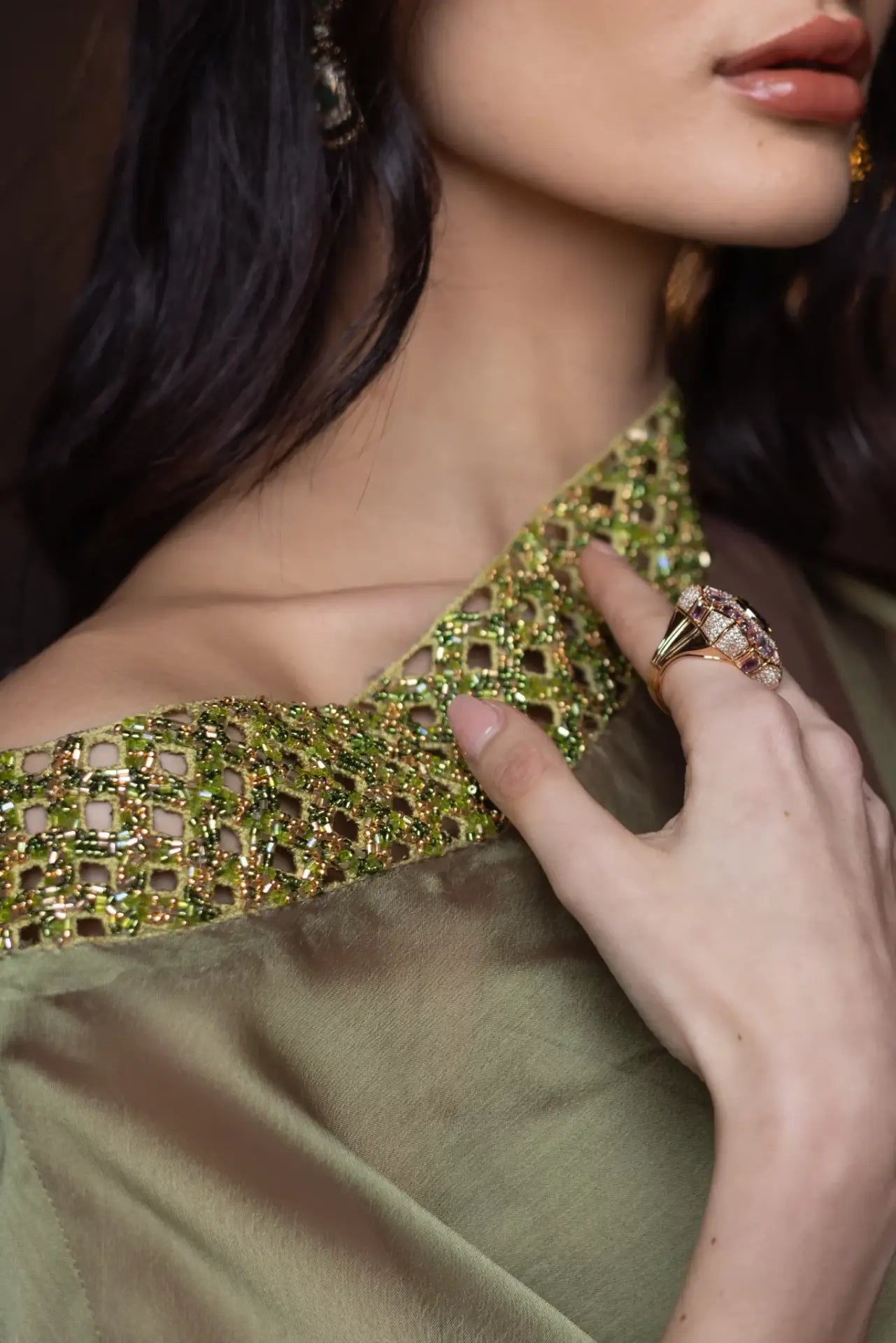 Close-up of the Baroque Dress Chiffon neckline, featuring hand-embroidered green beadwork on the one-shoulder design by Vérité Majestique PF2025.