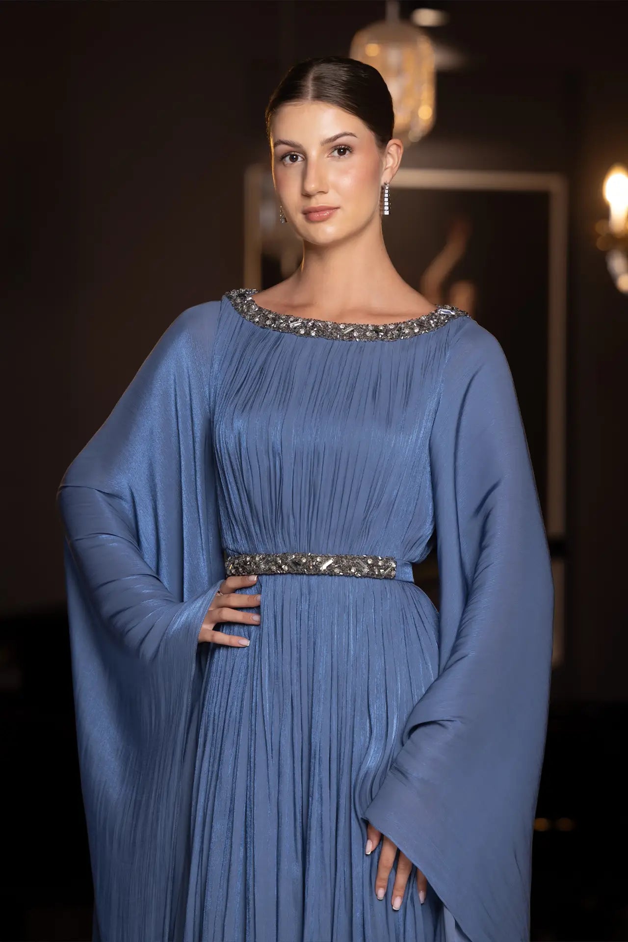 Close-up of Bloom Dress neckline and waist embellishment, showcasing intricate beadwork and pleated chiffon fabric in elegant blue.