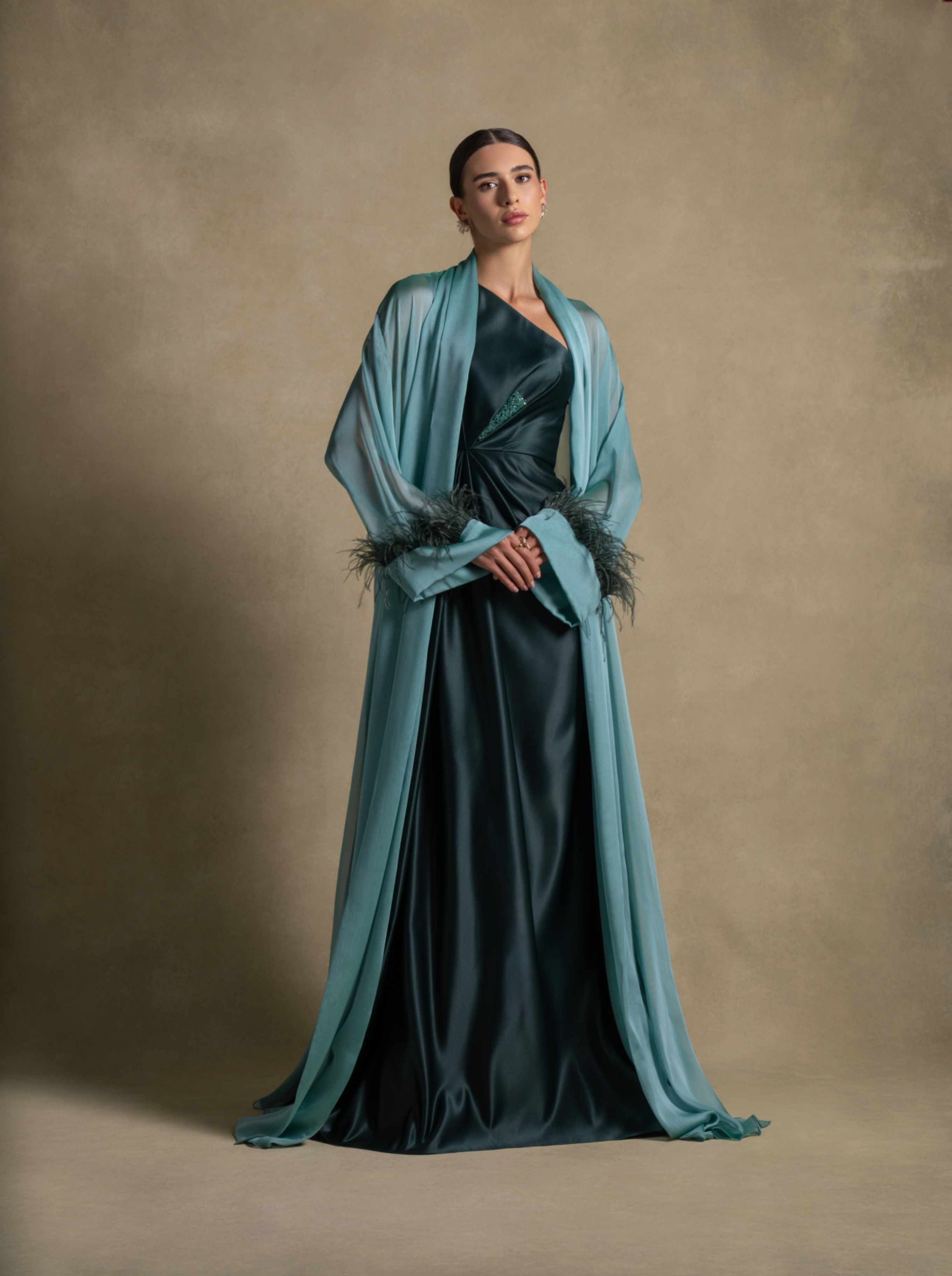 Blanche Set featuring a woman in a luxury emerald green taffeta satin gown with feather-trimmed cuffs, perfect for evening wear.