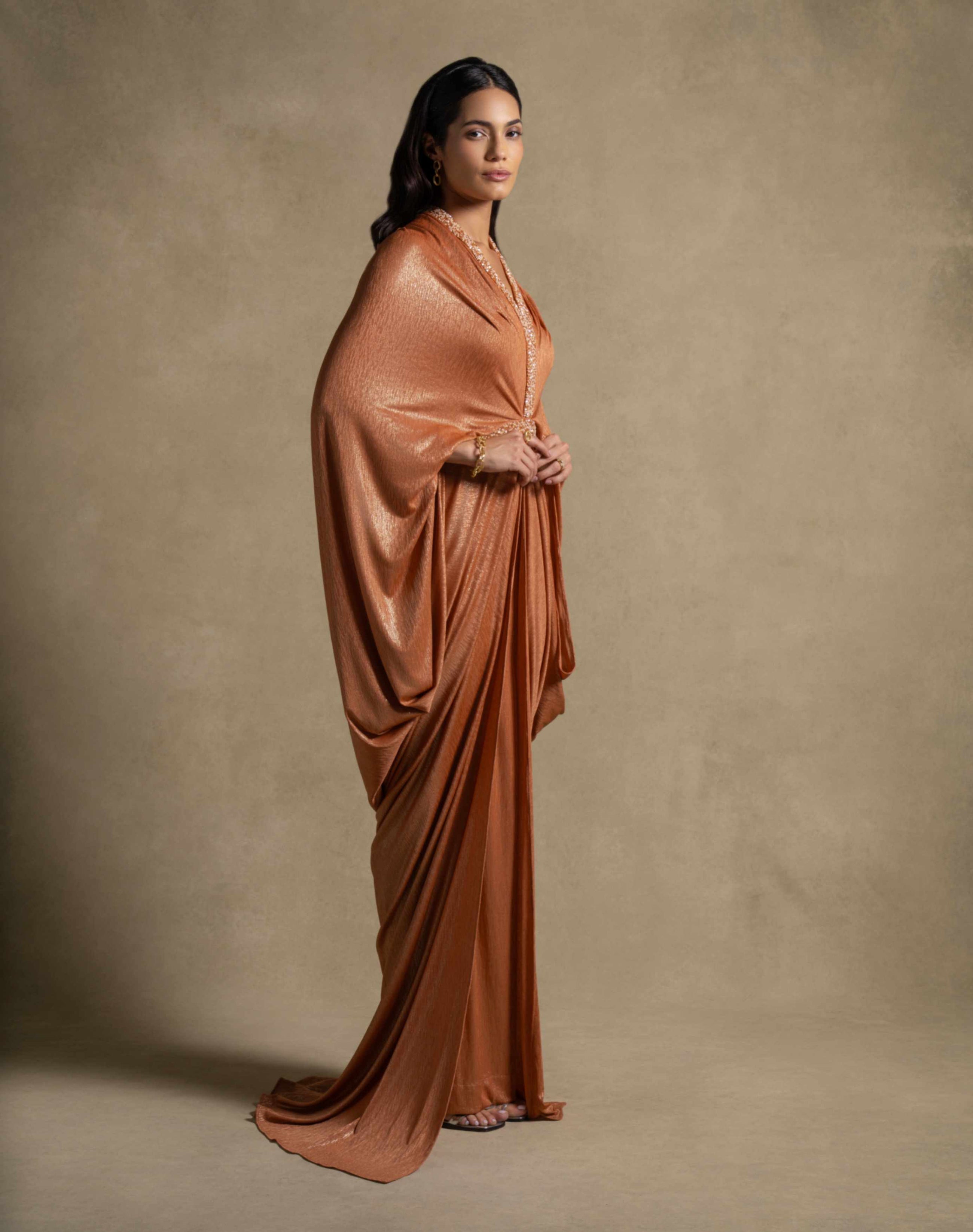 Model wearing Moon Set dress from the Zarina Collection, showcasing luxury orange kaftan evening wear.