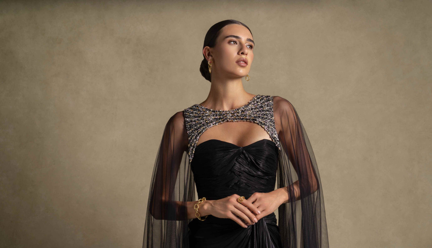 Zarina Collection SS2026 model showcasing high-end luxury evening wear on a balcony at sunset, epitomizing timeless elegance.