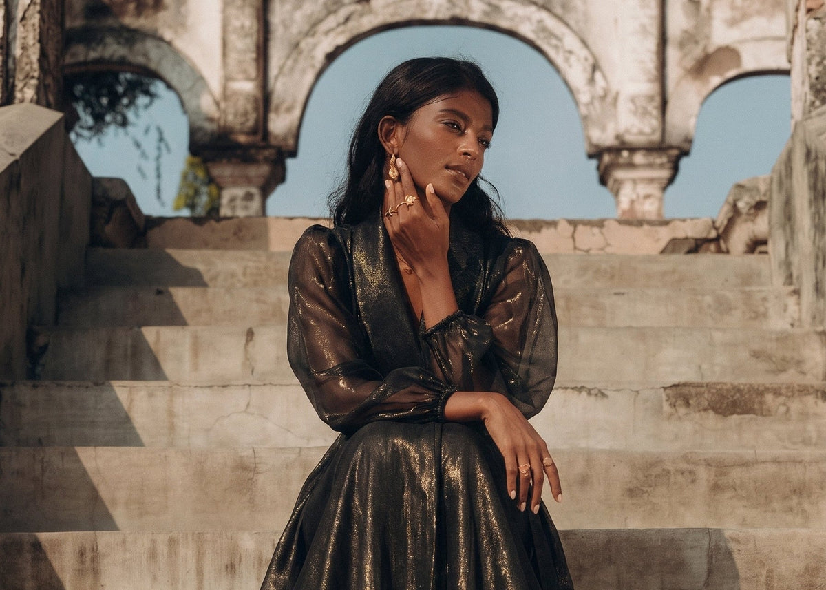 Esperanza Collection AW24 showcasing women in high-end luxury evening wear against a floral backdrop.