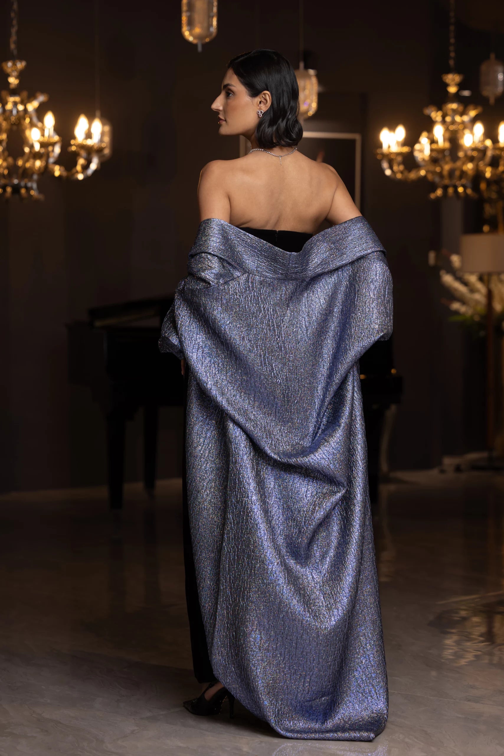Back view of MissOvo Set from Vérité Majestique PF2025, showing the flowing metallic shawl and strapless black gown. Sophisticated special occasion wear.