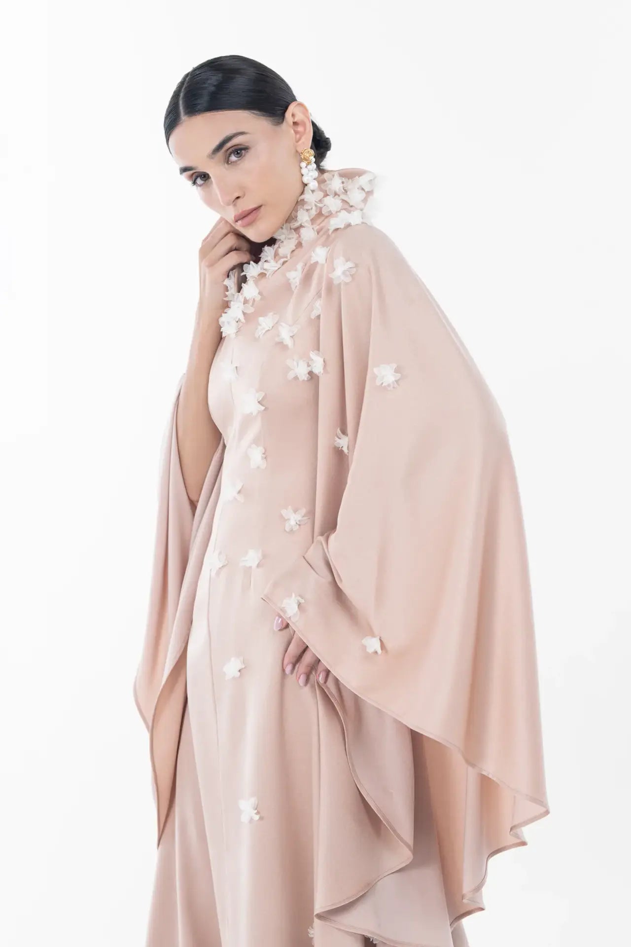 Side pose of model in Artista Allure Dress featuring draped sleeves and floral embellishments, from the Ramadan 2025 Eid collection.