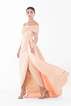 Model in Ispahan Dress from Artista Eid - AW 2025 showing movement of the flowing peach skirt and off-shoulder lace sleeve design.