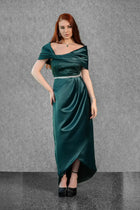 Front view of Maia Dress showcasing emerald green satin fabric, off-shoulder corset, crystal waistband, and draped asymmetric skirt design.