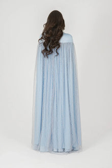 Back view of the Diamond Dress Baby Blue with flowing lace cape overlay, showcasing the gown’s graceful silhouette and full-length design.