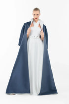 Model wearing Ava Set Artista Ramadan 2025, showcasing the elegant contrast between the white gown and navy satin coat.