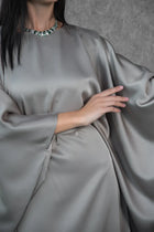 Close-up of the Ella Dress satin fabric and cape sleeves, showcasing the luxurious texture and elegant high neckline design.