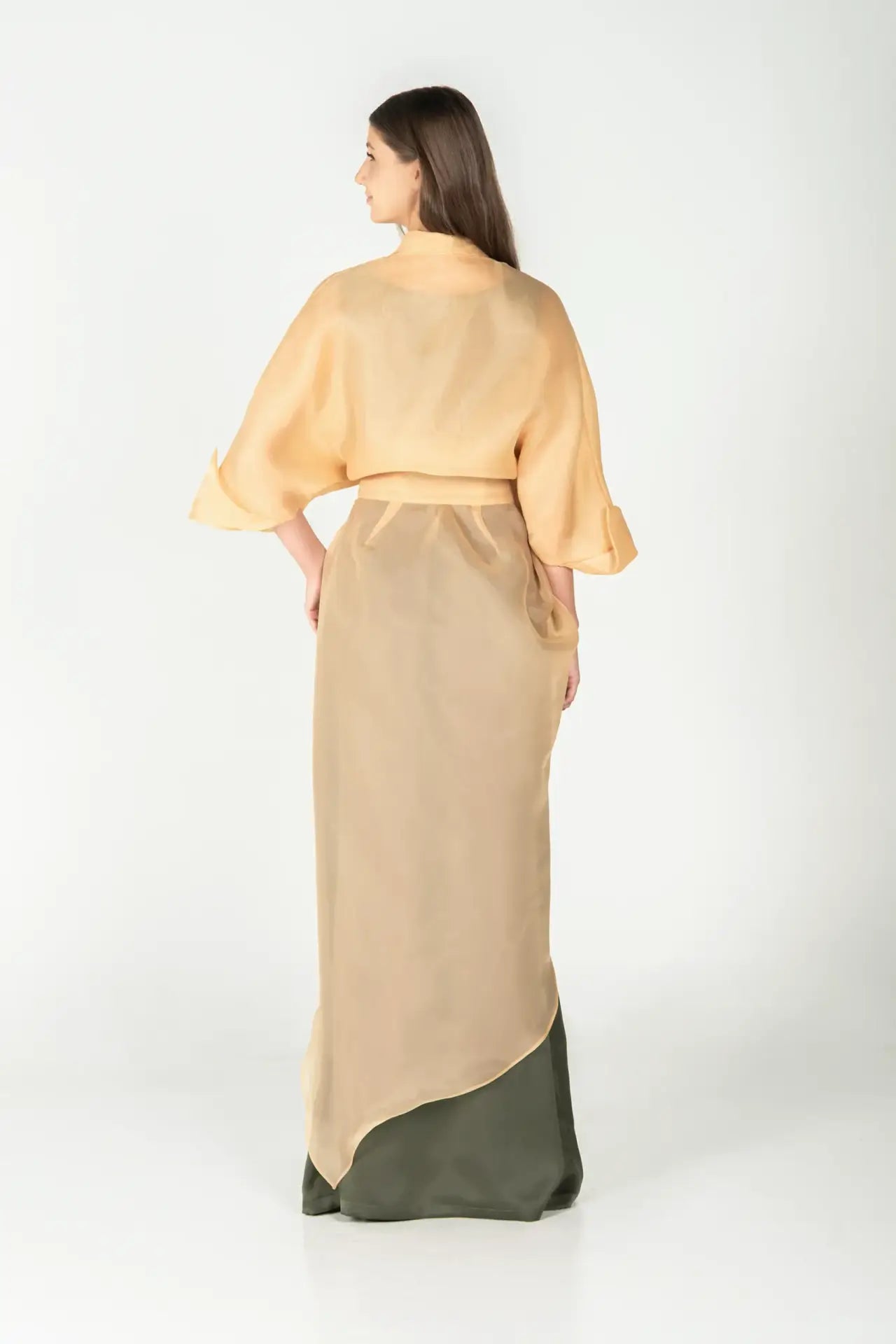 Back view of Jewel Dress - Organza Crepe with sheer gold sand overlay and olive green base, showcasing elegant draping and long silhouette.