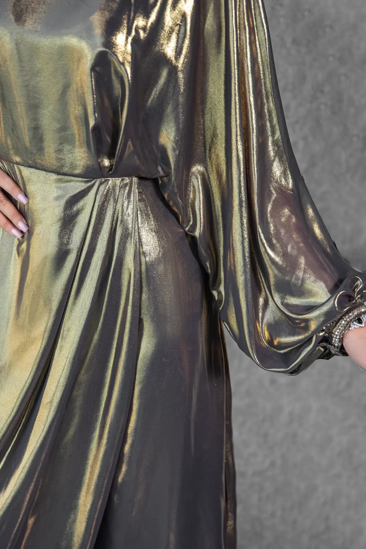 Close-up of Hera Dress pleated skirt and sleeve detailing in metallic gold silk and chiffon with fine embroidery and ruching.