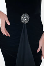 Detailed view of the Noir Dress brooch accent and velvet texture, highlighting the gown’s refined craftsmanship.