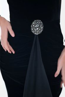 Detailed view of the Noir Dress brooch accent and velvet texture, highlighting the gown’s refined craftsmanship.
