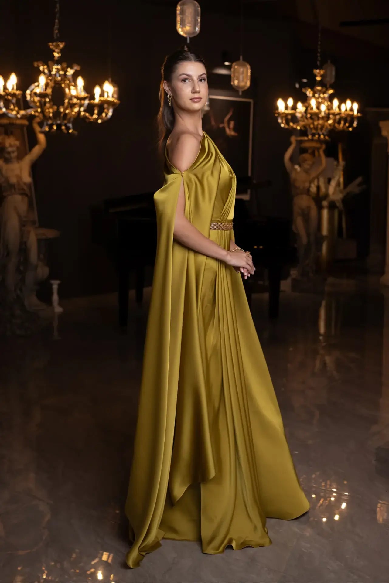 Side view of Ambre Dress - Olive Green One-Shoulder satin gown with flowing cape and cinched waist, perfect for upscale formal occasions.