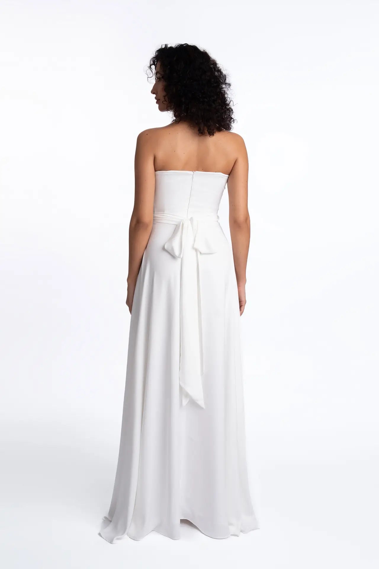 Back view of Alba Dress Elegant Gown featuring a strapless design with a tied bow and flowing skirt, perfect for weddings or evening events.