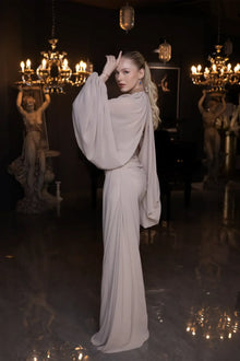 Back view of Elora Dress - Beige Chiffon Elegance showcasing the elegant drape and cape-style sleeves in a luxurious chiffon fabric.