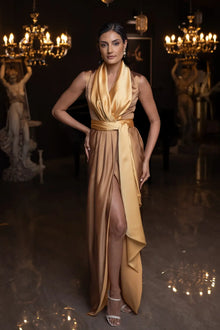 Kelly Set sleeveless gown with high slit and golden mustard draping, styled for luxury fashion occasions.