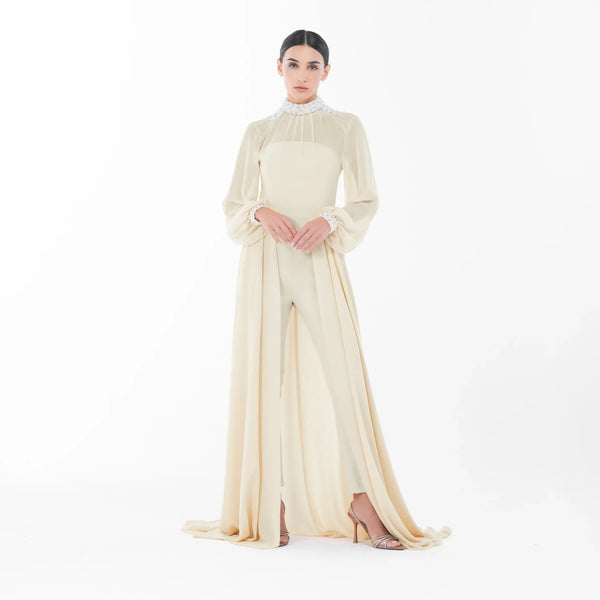 Gabrielle Jumpsuit in ivory, elegant high-neck design with pearl embellishments, perfect for luxury evening wear.