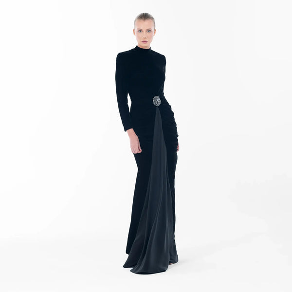 Noir Dress: Elegant black velvet gown with high-neck, long sleeves and statement embellishment for luxury evening wear.