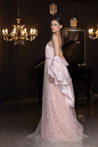 Miss Waad Dress by Verite Majestique PF2025 with feathered hem detail and sheer overlay, styled with voluminous blush cape.