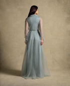 Back view of the Gilded Dress showcasing sage green flowing silhouette and sheer organza sleeves, perfect for evening wear.