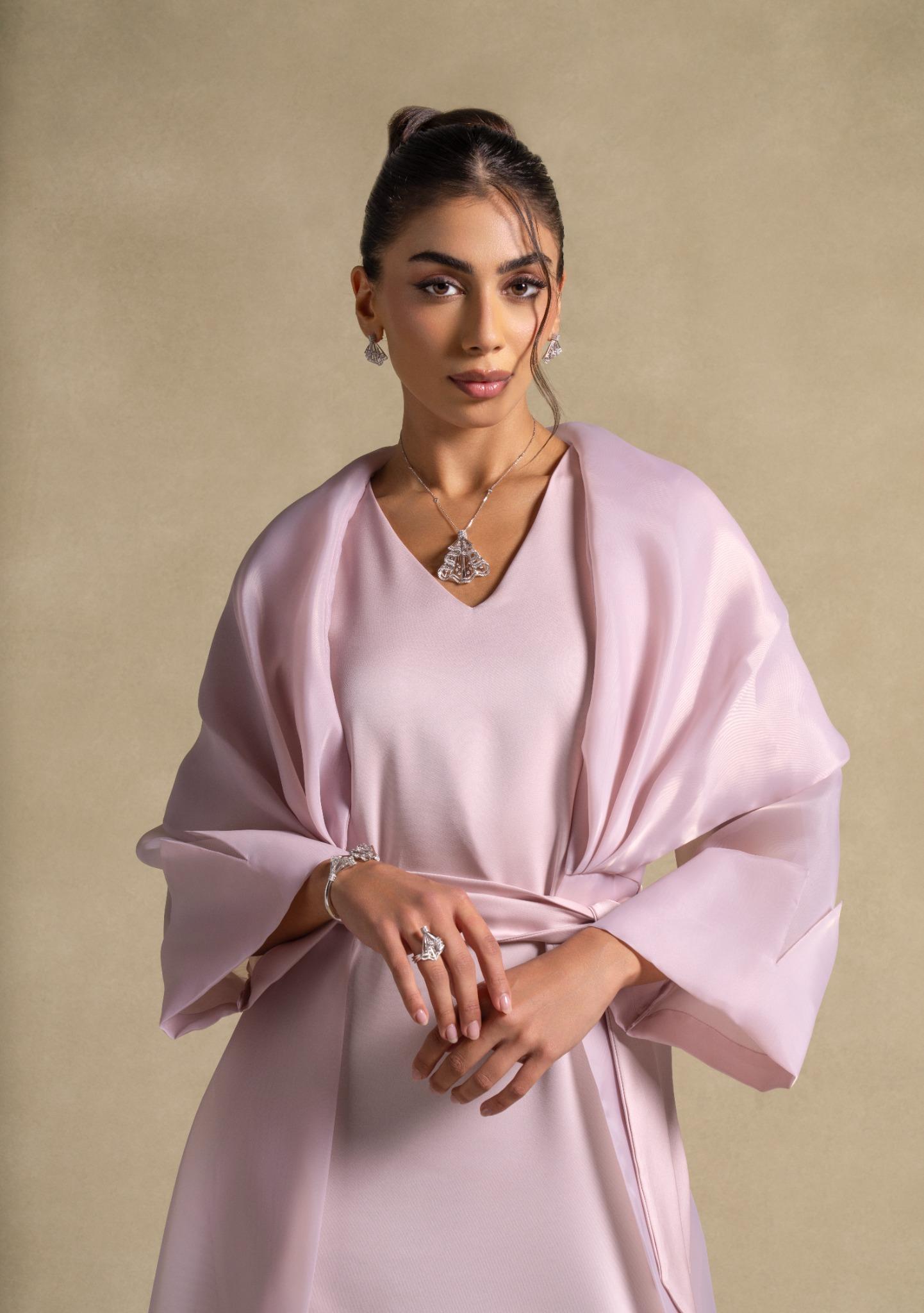 Isis Set worn by a model featuring luxurious pink quartz fabric and elegant shawl, representing high-end women's fashion.