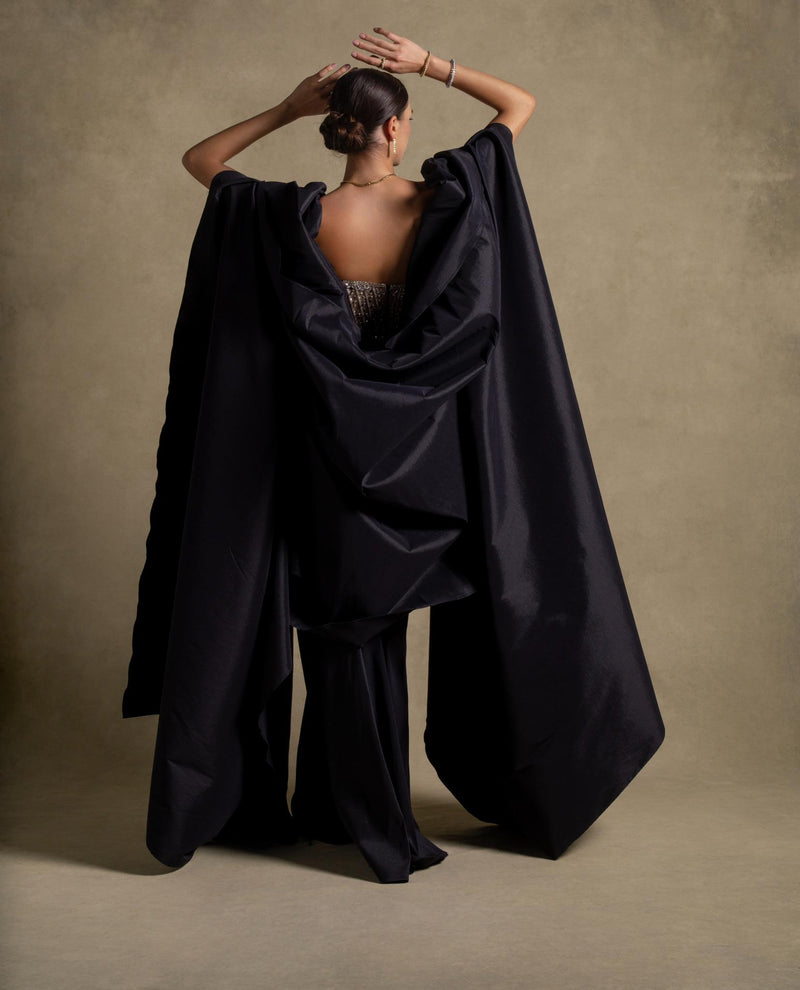 Model showcasing the Marguerite Set, highlighting its luxurious black draped skirt and glamorous beaded corset design.