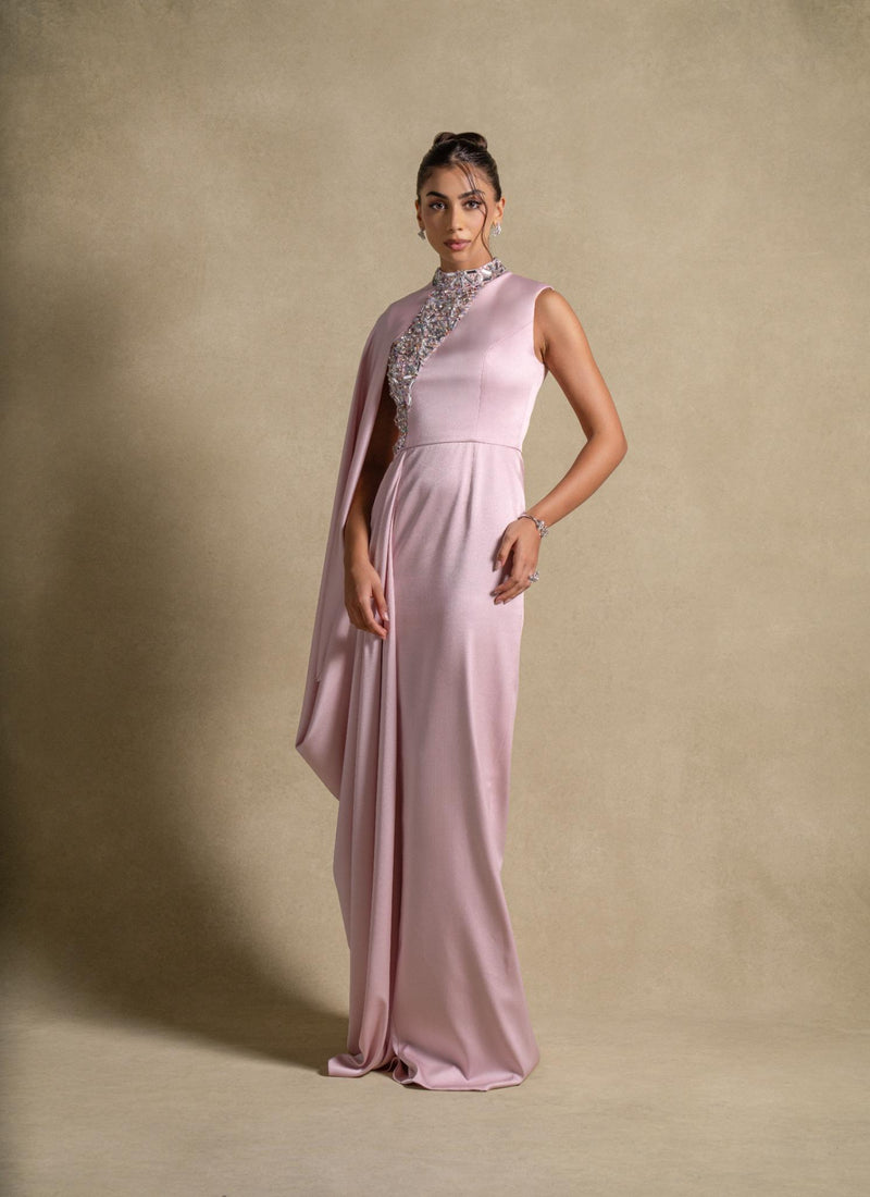 Aaliyah Dress in soft Pink Quartz satin showcasing luxury fashion with crystal embellishments and a flowing cape.