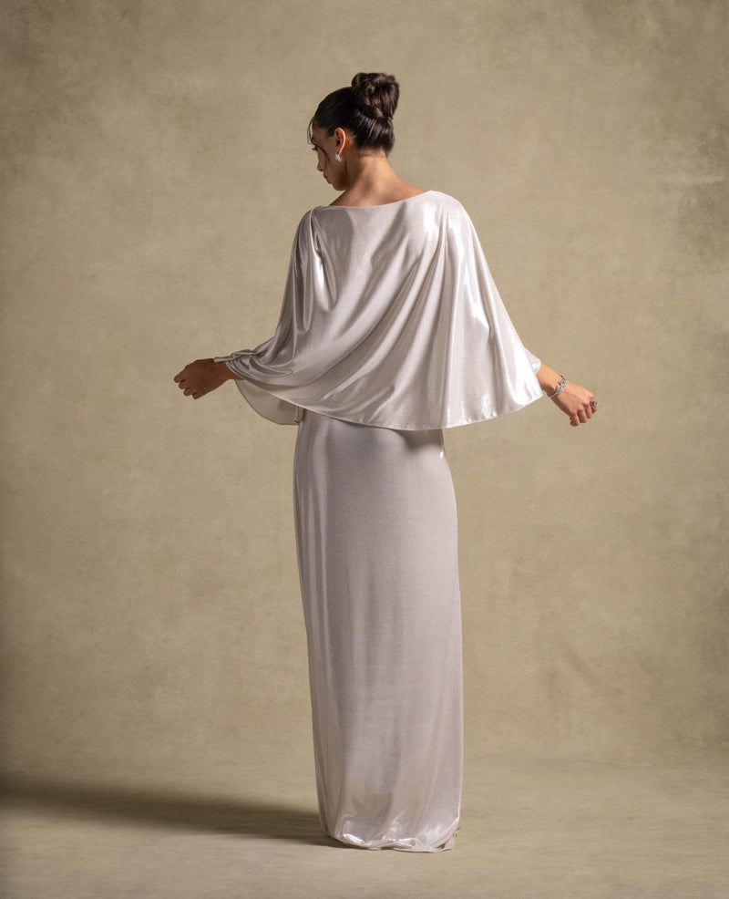 Back view of a model wearing the Serena Dress, a luxurious silver gown from the Zarina Collection.