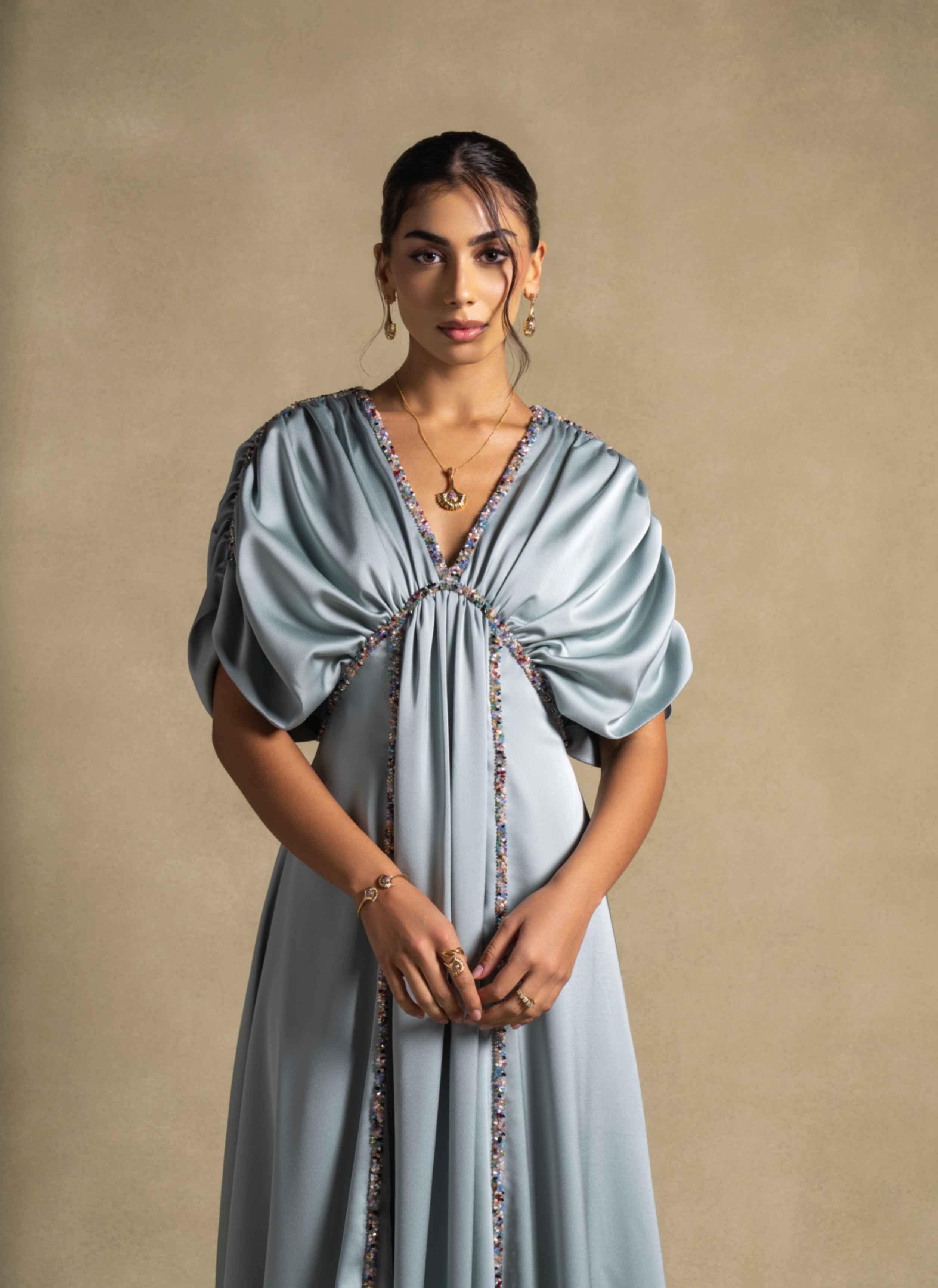 Cyra Dress showcasing a sage green gown with gathered bodice and soft volume sleeves, perfect for high end fashion and evening wear.