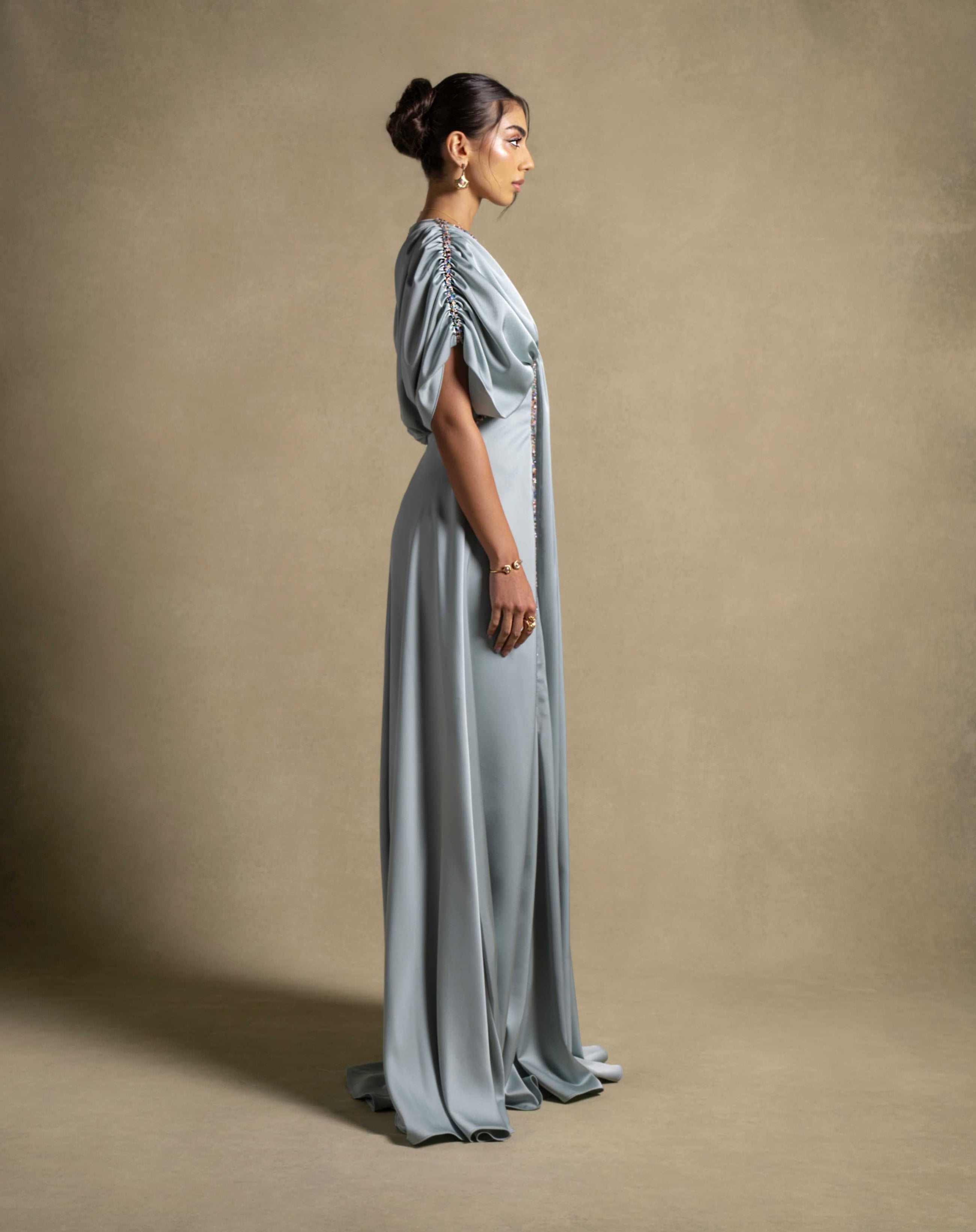 Cyra Dress in sage green, a luxury maxi dress showcasing soft volume sleeves and delicate embroidery, perfect for high-end evening wear.