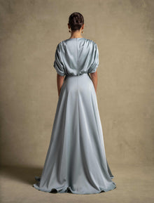 Back view of the Cyra Dress, a luxury sage green maxi dress with soft volume sleeves and elegant drape.