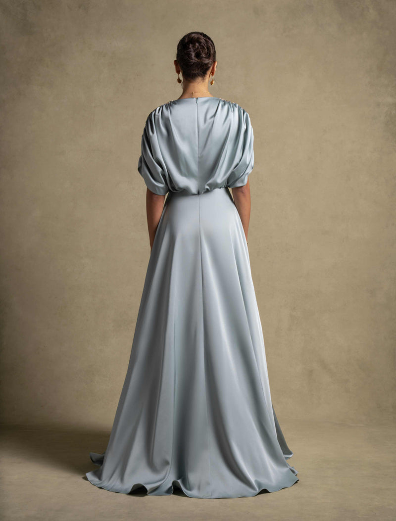 Back view of the Cyra Dress, a luxury sage green maxi dress with soft volume sleeves and elegant drape.