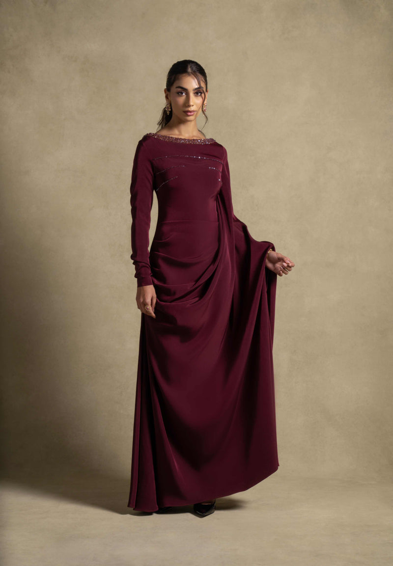 Roxana Dress in maroon from the Zarina Collection, featuring elegant draped detailing and embellished neckline for evening wear.