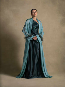 Blanche Set featuring a woman in a luxury emerald green taffeta satin gown with feather-trimmed cuffs, perfect for evening wear.