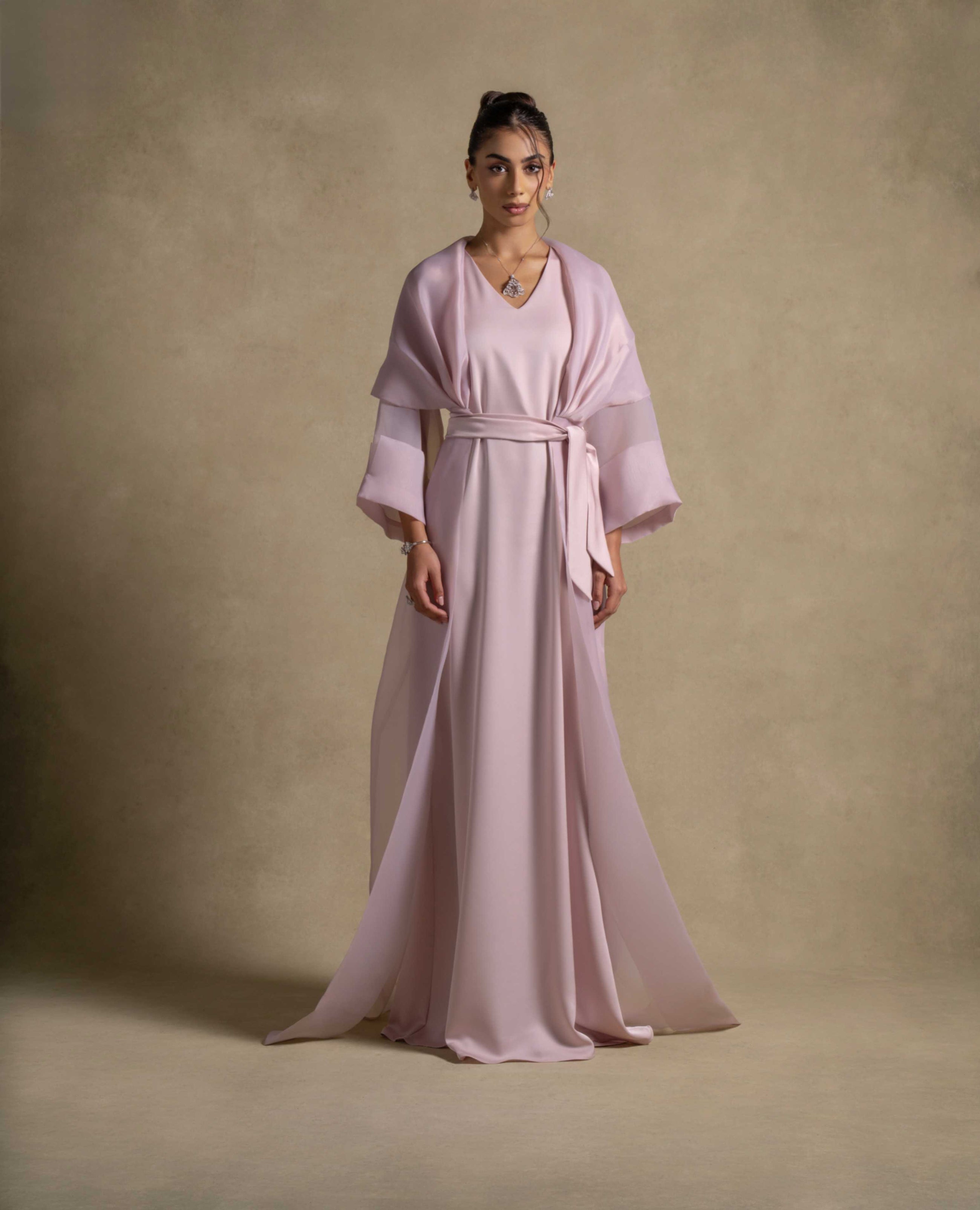 Isis Set showcasing a luxurious pink quartz maxi dress with a belted waist and sheer organza overlay, perfect for evening wear.