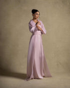 Isis Set model wearing a pink quartz maxi dress from the Zarina Collection, showcasing luxury evening wear.
