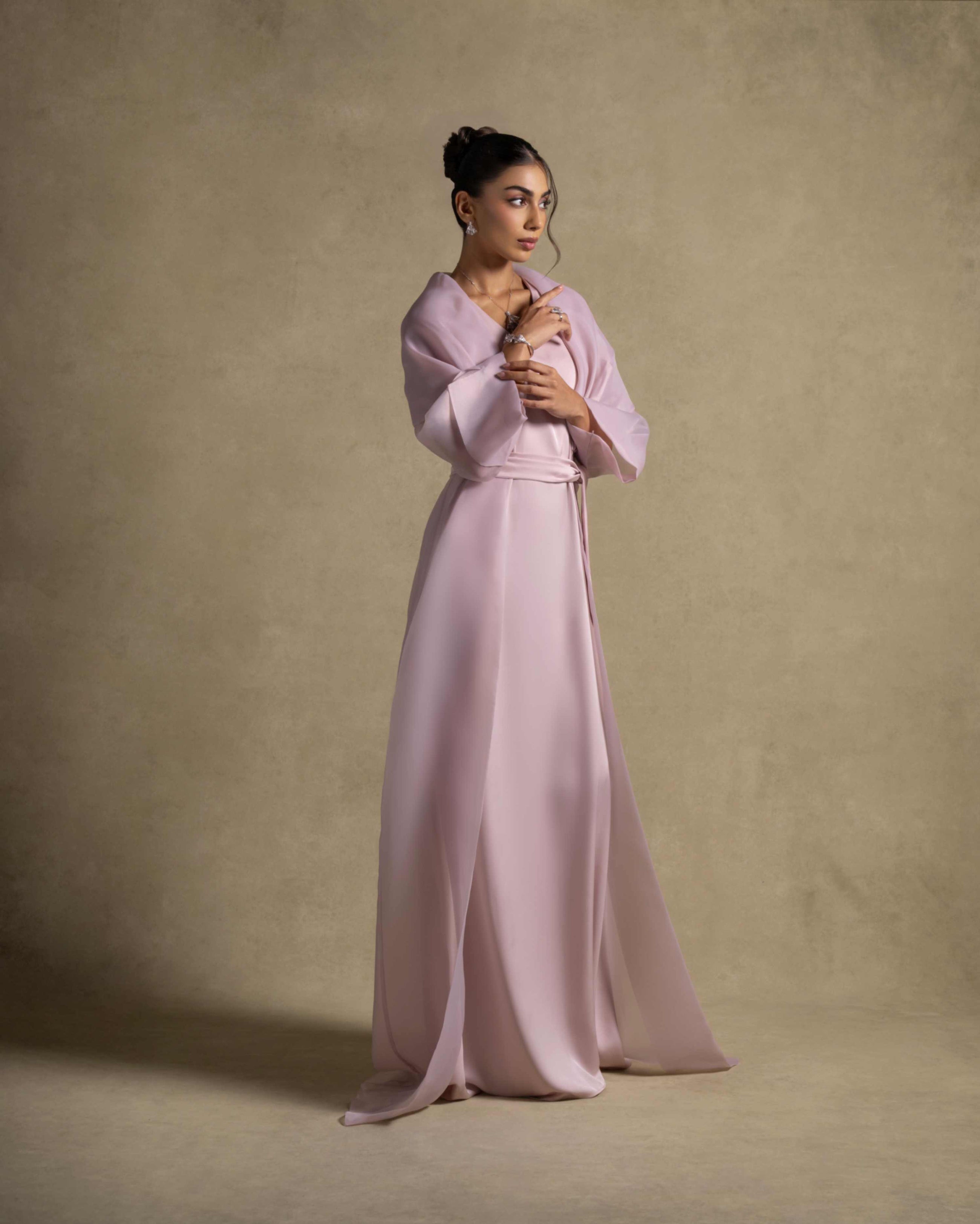 Isis Set model wearing a pink quartz maxi dress from the Zarina Collection, showcasing luxury evening wear.
