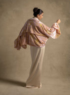 Elegant woman in the Selene Set showcases luxury ready-to-wear evening wear with a satin gown and a shimmering cape.