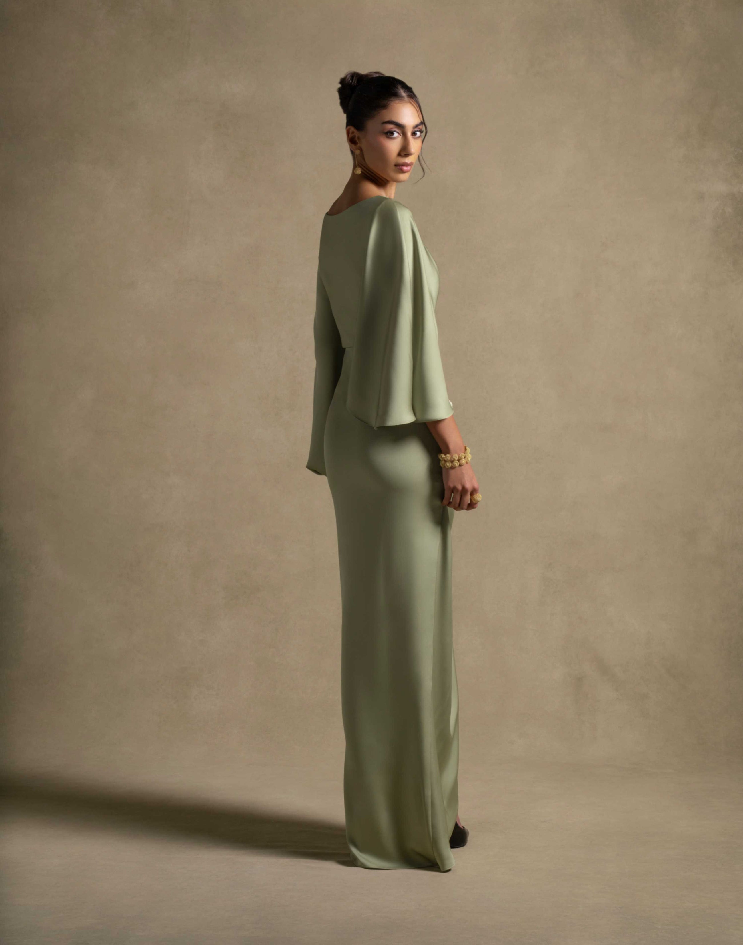 Renee Dress in pistachio color, showcasing luxury evening wear with draped sleeves and an elegant silhouette.