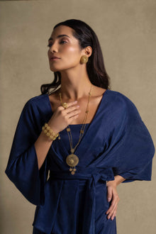 Palatino Set model showcasing Denim Blue wrap jacket and accessories, representing luxury women's clothing and high end fashion.