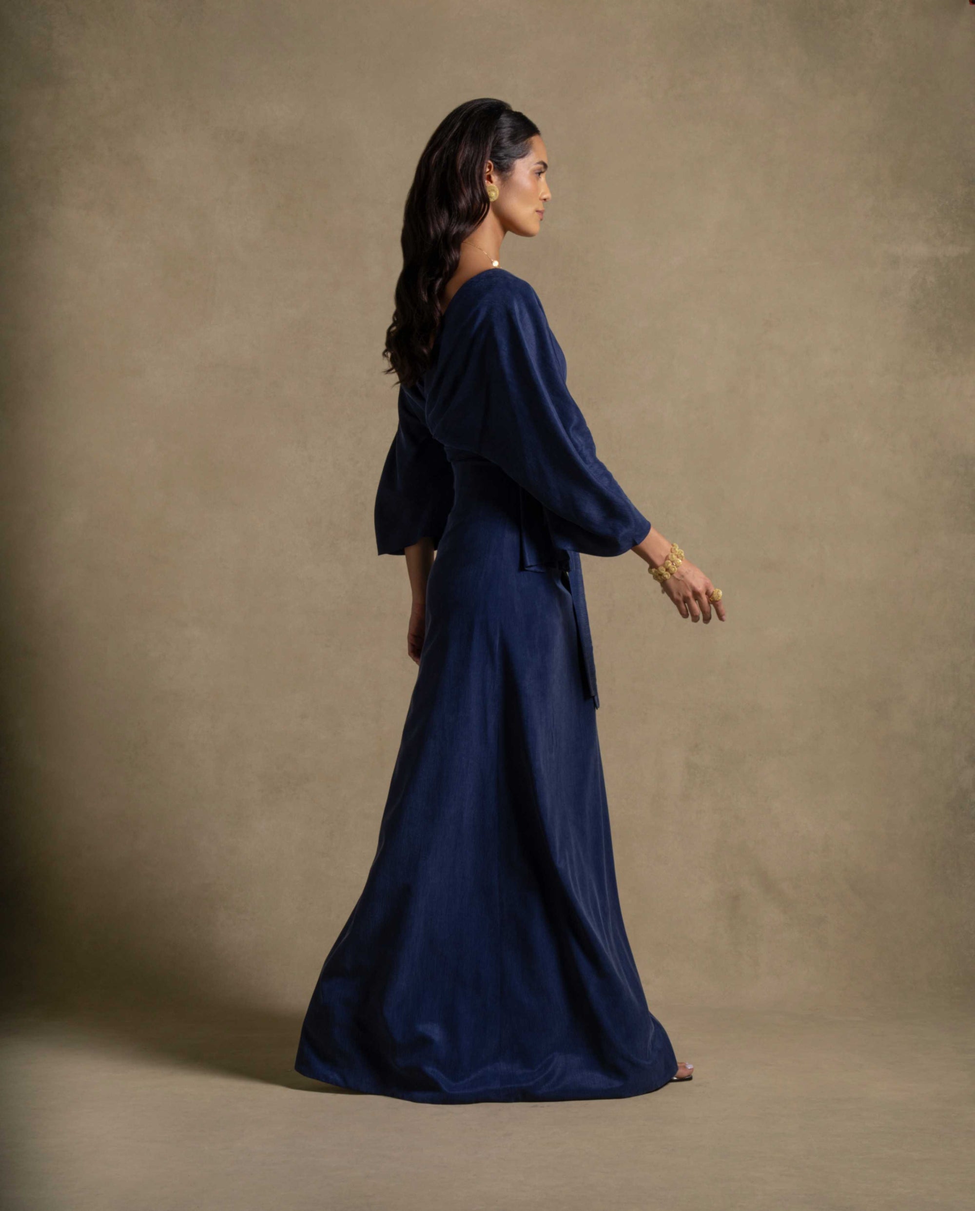 Palatino Set featuring a model in a denim blue belted wrap jacket and floor-length maxi dress.