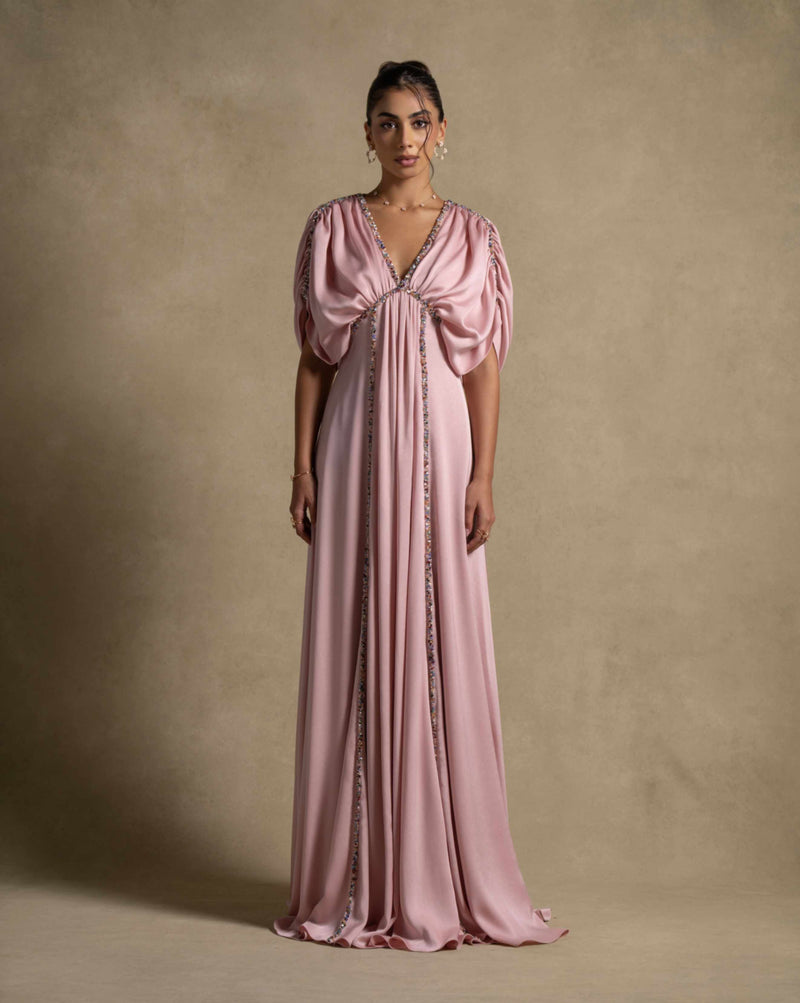 Lara Dress in baby pink, featuring gathered detailing and embellished trims, perfect for evening wear and luxury celebrations.